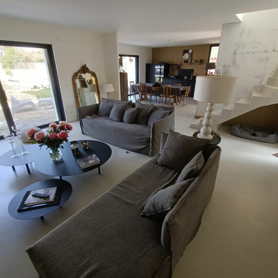 Béton ciré appliqué au sol et aux murs dans un salon, une salle à manger et sur les escaliser